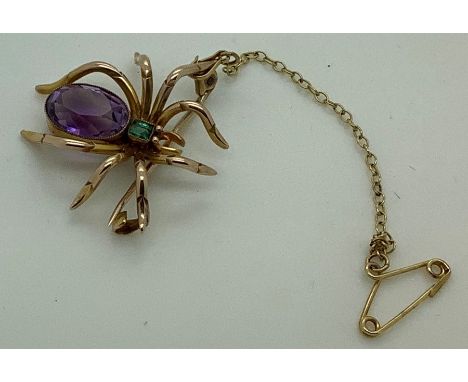 A vintage spider brooch with purple stone to body and green to head, marked 9 carat with safety chain. 4.6gms. 2.5 x 2.5cms. 