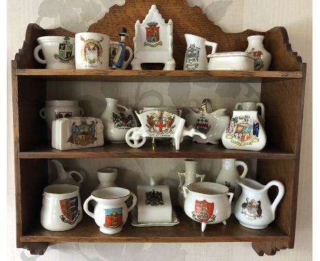 Twenty four various items crested ware including Withernsea, Scarborough etc to include oak wall hanging shelf. 36 h x 32cms 