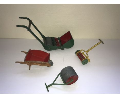 Four Dinky playworn metal gardening implement toys comprising a Dinky Toys wheelbarrow, a Meccano push lawn mower, garden rol