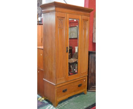 An Edwardian satinwood wardrobe, ogee cornice, mirrored door flanked by carved panels, deep drawer to base, copper Art Nouvea