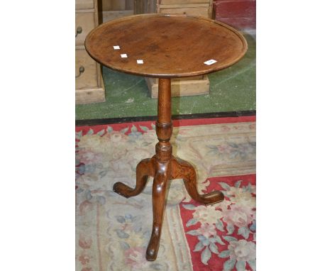 A George III oak tripod table, dished circular top, turned column, cabriole legs, pad feet.