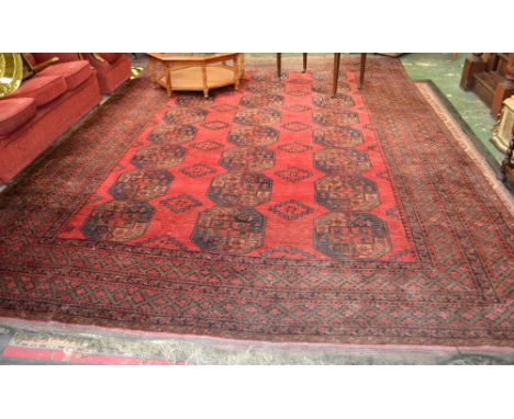 A Bakara Indian hand woven carpet, geometric designs in hues of indigo, orange and black on a red ground, c.1900