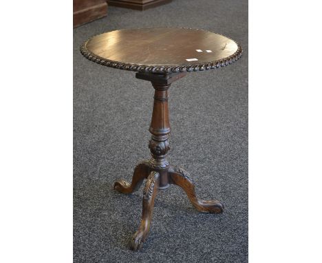 A reproduction mahogany tilt top tripod table, circular top, gadrooned border, turned column, cabriole legs, acanthus carved 