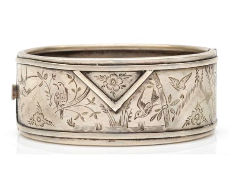 A Victorian unmarked silver hinged bangle, engraved with birds, 57 x 41mm, 35gm 