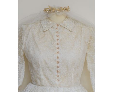 A cream lace vintage wedding dress with veil and pearlised floral and bead circlet headdress. The beautiful dress shows very 