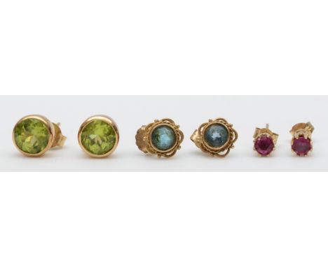 A 9ct gold pair of peridot ear studs, a ruby pair and a topaz pair, 2.7gm 