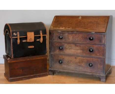 An early 20th century oak bureau, a single lockable hinged door opens to reveal a fitted shelved interior, over three graduat