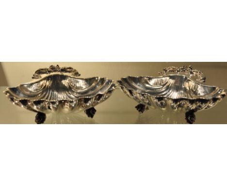 A pair of early 20th Century silver plated scallop shaped bonbon dishes, each on three cast shell feet, by Henry Wilkinson & 