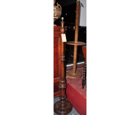A 1920s carved oak standard lamp together with two further oak and fruit wood standard lamps