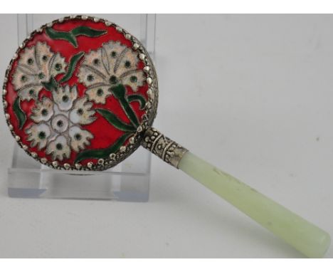 A Chinese jade and white metal hand mirror with enamel flower blossom