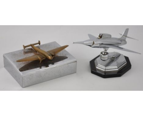 A vintage chrome cigarette lighter, modelled as a jet airplane, on octagonal stepped swivel base, together with a plated ciga