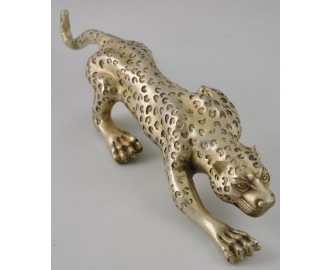 A Chinese white metal figure of a leopard hunting