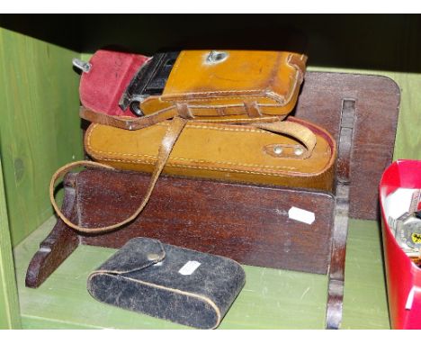 Leather cased Kodak camera, shelf bracket, vest pocket Kodak, and another