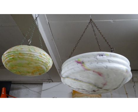 A large marbled glass hanging light bowl, with chains, and a smaller yellow and green light bowl