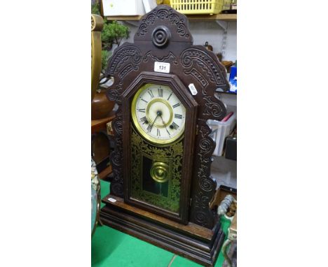 A 2-train mantel clock, in carved wood surround