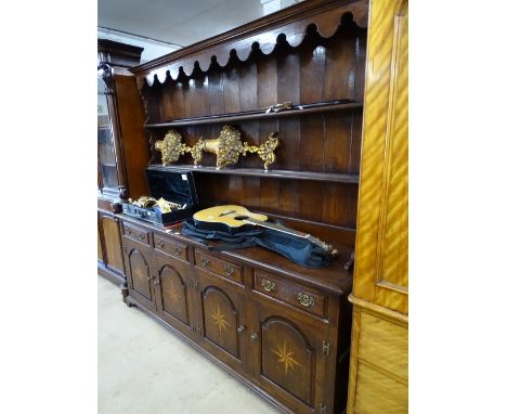 A good reproduction oak Welsh dresser,with boarded open plate rack, the base fitted with 4 frieze drawers and 4 fielded panel