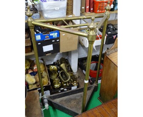 A brass corner stick stand, on cast iron base
