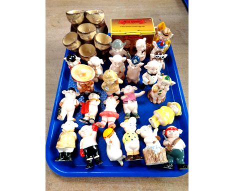 A tray of Friar Chucky ceramic egg holder and quantity of china pig ornaments 