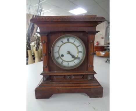 A pine cased mantel clock with enamel dial