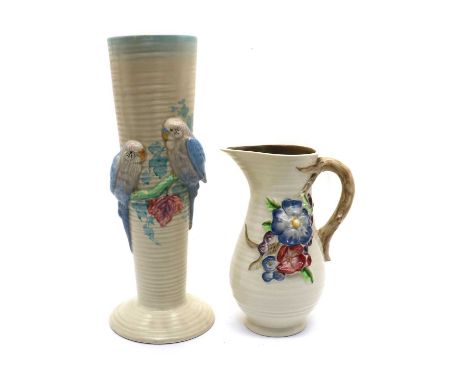 A Clarice Cliff 'Budgerigar' vase,31.5cm high together with a similar jug, moulded with flowers, 20cm high (2)Both fair. The 