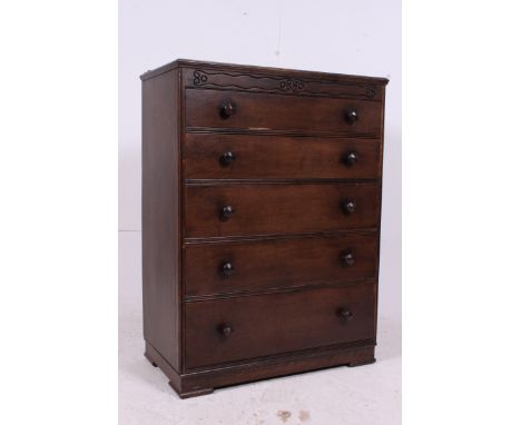 A 1930's Jacobean revival oak tall chest of drawers. The drawers to base, each with original handles being raised on bracket 
