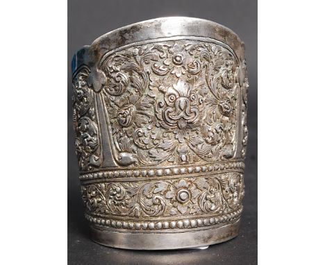 An Indian silver early 20th century bangle / bracelet of large form cast in relief with scroll work. Weight 70.6g