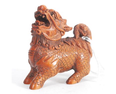 A Japanese oriental carved wood netsuke of a temple dog