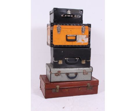 A stack of vintage trunks to include leather suitcase, yellow steamer trunk, modern leather example etc