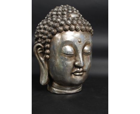 A 20th century faux stone large buddhas head in silver colour