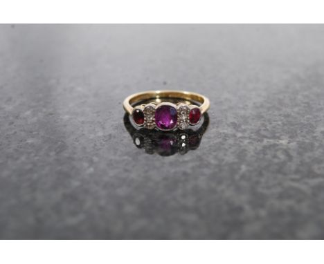 An 18ct gold and platinum ladies ring, inset with three ruby red stones to top. Size M/N