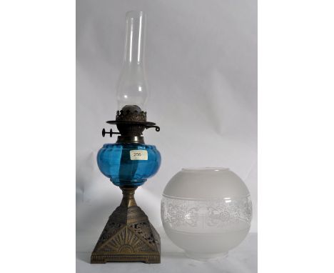 A 19th century blue glass oil lamp. The cast iron pierced base with blue glass reservoir having etched glass shade and flue a
