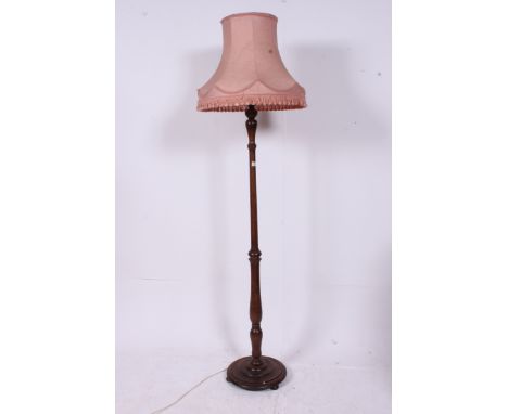 A 1930's mahogany standard lamp raised on terraced base complete with large fabric shade Measures: 200cms H.