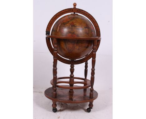 An antique style reproduction 20th century globe drinks cabinet, the globe opening to reveal a fitted interior for holding bo