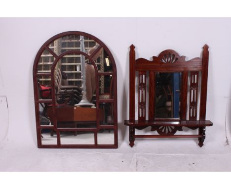 A Victorian style mahogany wall mirror with shelf together with a resin cast arched mirror