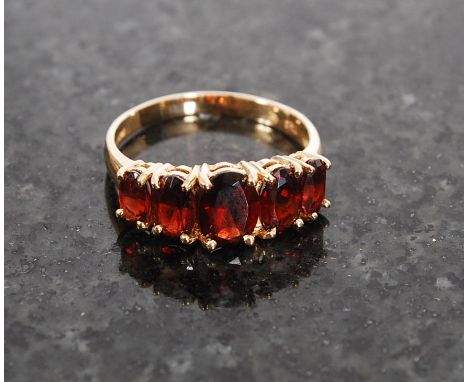 A 14ct gold ruby garnet 5 stone ring being stamped to the hoop 14k. Size L/ M, weight 3.0g