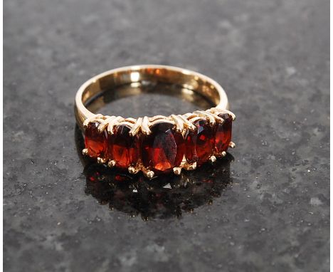 A 14ct gold ruby garnet 5 stone ring being stamped to the hoop 14k. Size L/ M, weight 3.0g