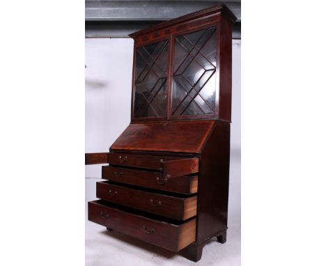 An oversized 19th century Georgian mahogany inlaid bureau bookcase. Raised on bracket feet with a chest of drawer having fall