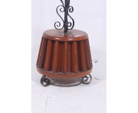 An unusual teak beer barrel standard lamp being raised  wooden base rococo upright above.  H167cm x W37cm