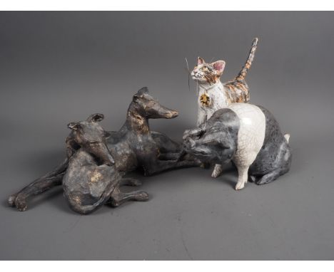 A Raku model of a pig, 4 3/4" high, a stoneware model of two recumbent greyhounds, 5" high, and a Raku "Mizzie" cat, 6 1/2" h