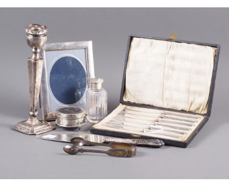 A filled silver candlestick, 8 1/4” high (damages), a silver handled cake slice, a silver topped scent bottle, a pair of silv