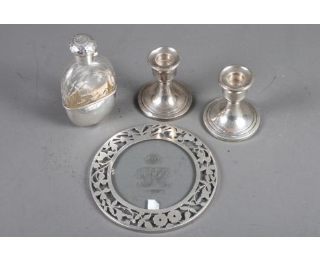 A glass spirit flask with silver cap and removable cup, a silver mounted glass teapot stand and a pair of silver dwarf candle