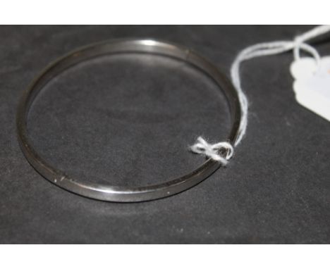 A 9 ct white gold hinged oval bangle of plain design, 6.2 grams