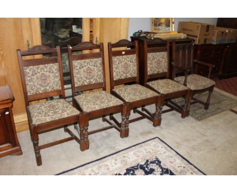 A set of four 20th century oak chairs with tapestry style upholstery and sold together with a 20th century oak carver chair w