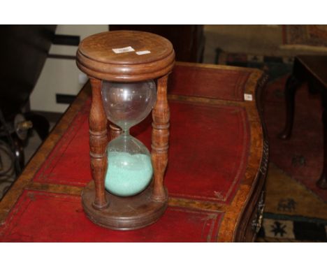 A large 20th century stained beechwood and clear glass egg or sand timer, 34 cm high