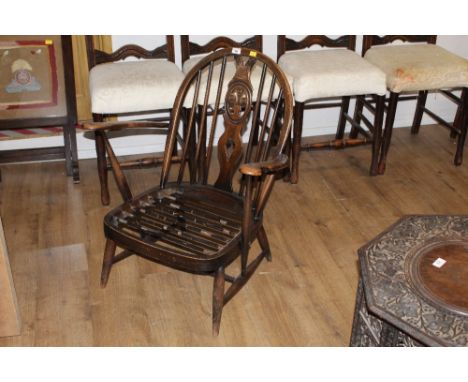 An Ercol dark elm low armchair with sprung seat, back 82 cm high