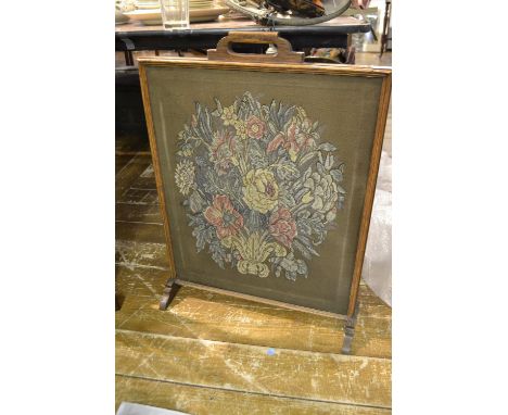A 1920's oak and embroidered fire screen. H.76cm