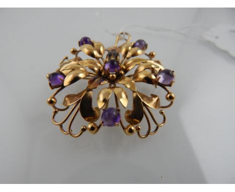A Continental yellow metal and amethyst pendant brooch of floral design, set five cabouchon amethysts, stamped 750 to verso.