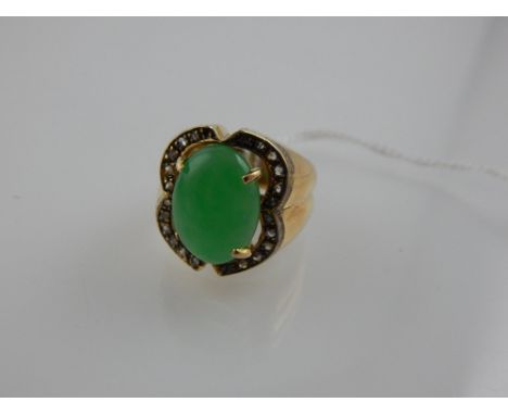 A yellow metal, diamond, and jade ring, the central cabouchon jade surrounded by a diamond set quatrefoil mount. 
