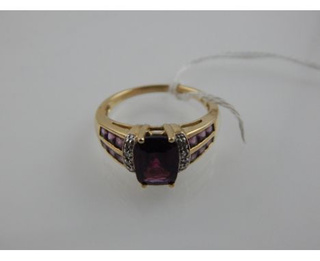 A 9 carat yellow gold, amethyst, and diamond set dress ring. 