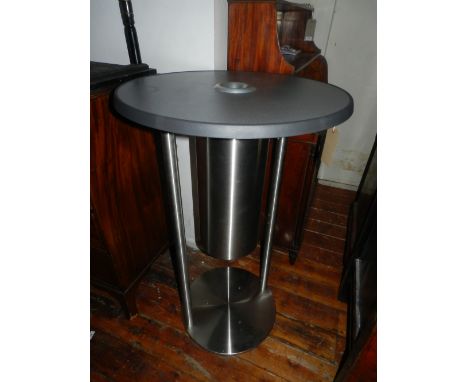 A brushed stainless steel garden table, centered with an ashtray on a tripod base. H.111cm D.70cm